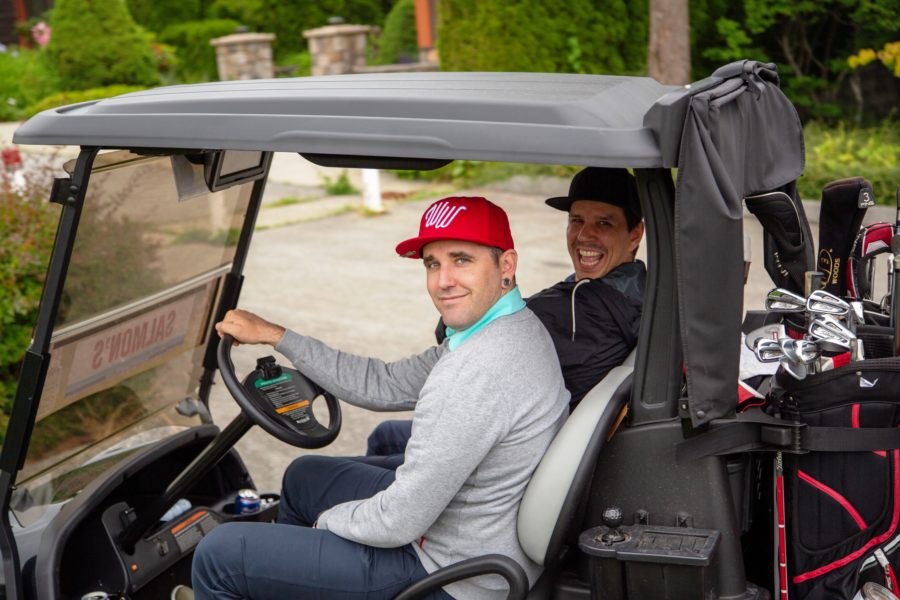 Golfers in cart the Whiskey Wisemen Charity Tournament at Westwood Plateau Golf Club